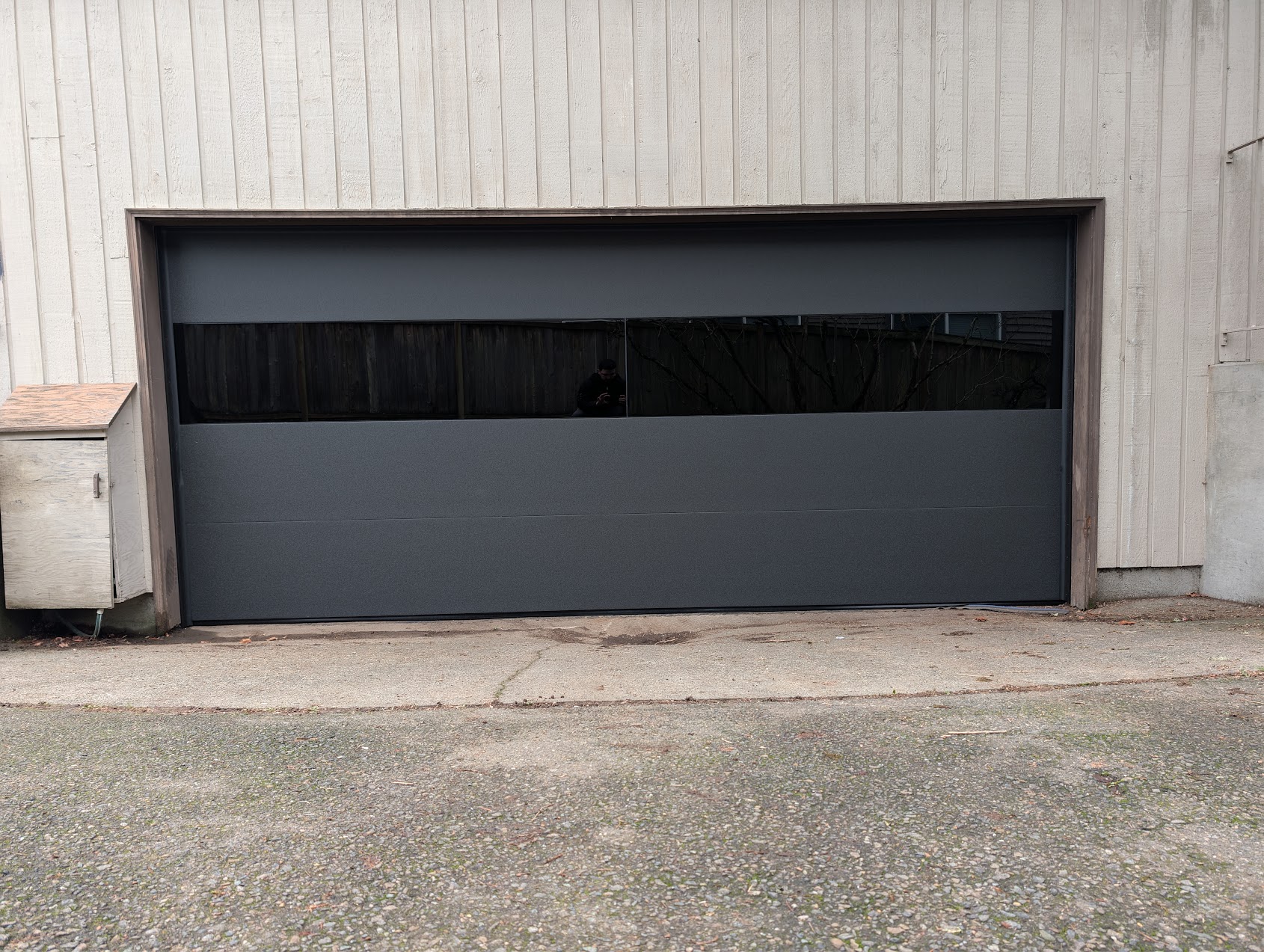Modern charcoal steel garage door with glass panels installed in Bellevue, WA