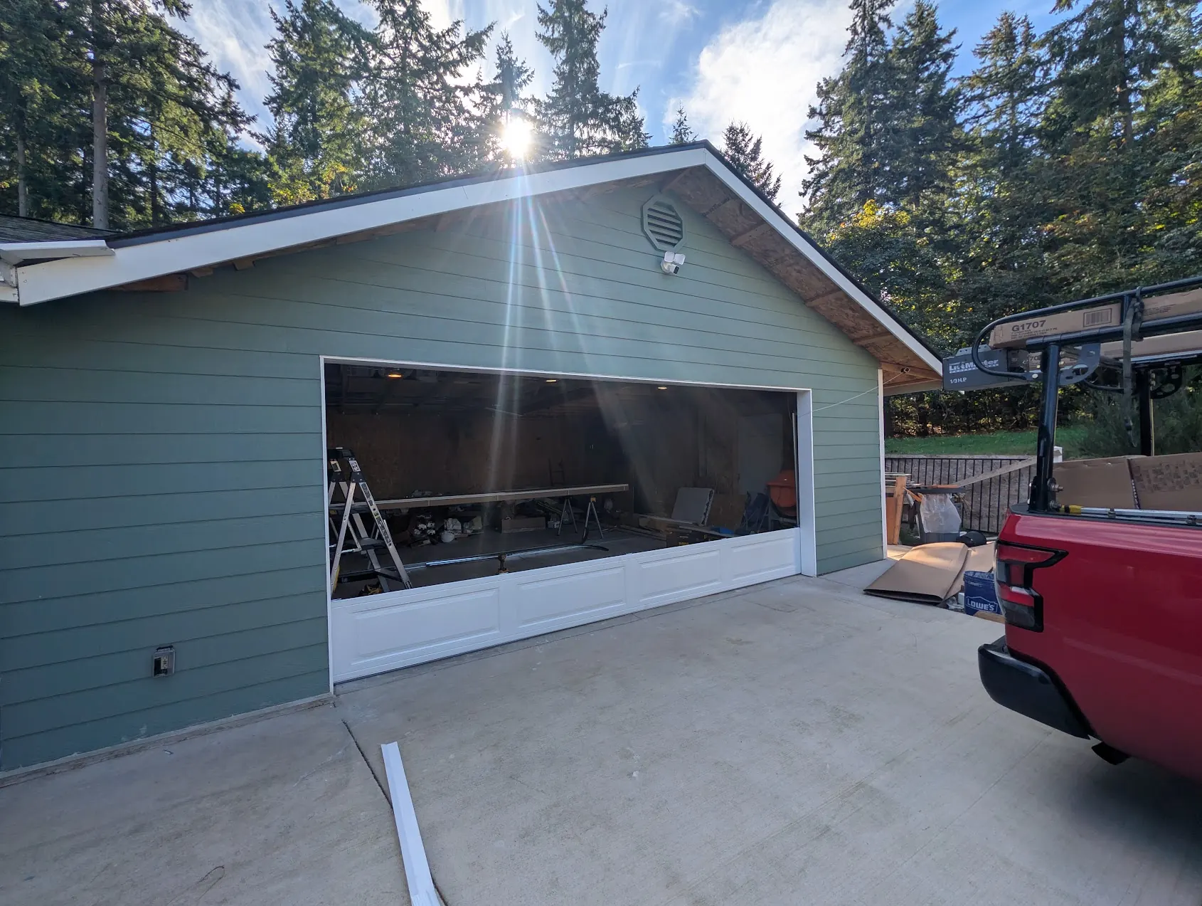 New white garage door going into the opening of a detached Federal Way garage with green siding