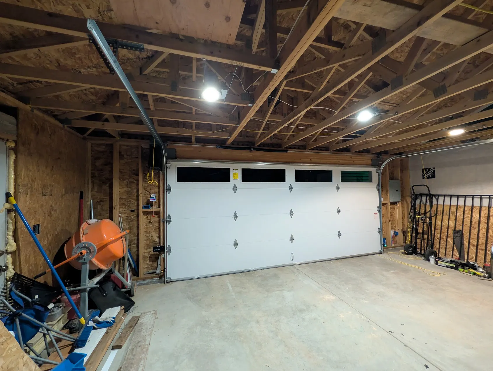 New white steel sectional garage door seen from inside a Federal Way garage with open trusses
