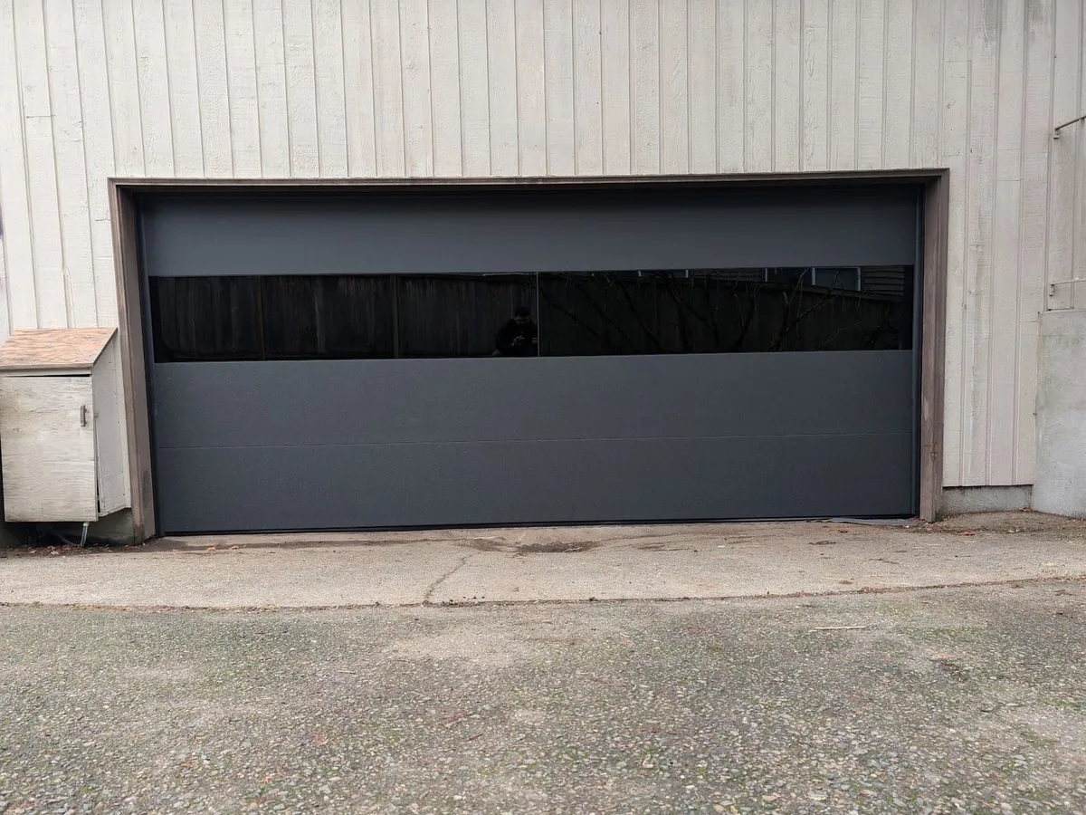 Charcoal modern flush garage door with a full width tinted glass band