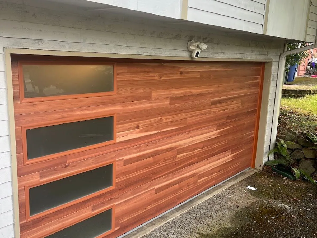 Wood look garage door with horizontal planks and four frosted glass panels